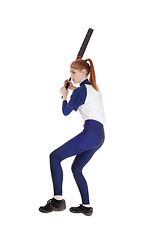 Image showing Woman swinging her bat in softball leg up