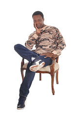 Image showing Tall African American man sitting in armchair