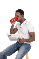 Image showing African man drinking coffee, reading the paper