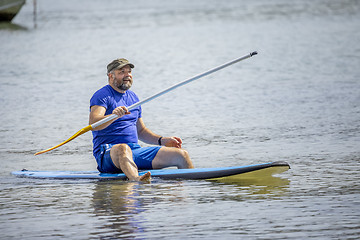 Image showing a bearded man paddling in the ocean