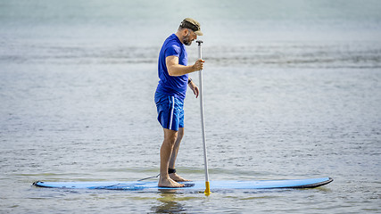 Image showing a bearded man paddling in the ocean