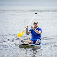 Image showing a bearded man paddling in the ocean