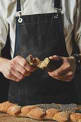 Image showing halves of baguette in the hands of a baker