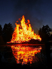 Image showing Flames of a huge bonfire at night near lake