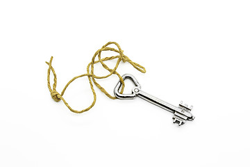 Image showing Old silver key on a rough rope on white background