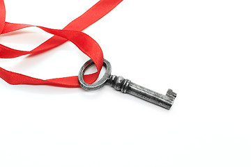 Image showing Vintage silver key with red ribbon on white background