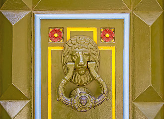 Image showing Old metal doorknob in the shape of lion head on old wooden door