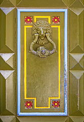 Image showing Old metal doorknob in the shape of lion head on old wooden door