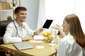 Image showing Smiling nutritionist showing a healthy diet plan to patient