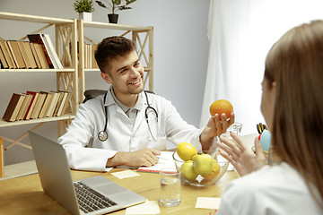 Image showing Smiling nutritionist showing a healthy diet plan to patient