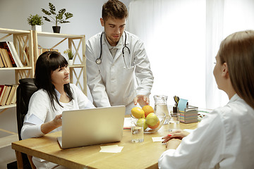 Image showing Smiling nutritionists showing a healthy diet plan to patient