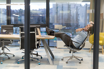 Image showing young businessman relaxing at the desk