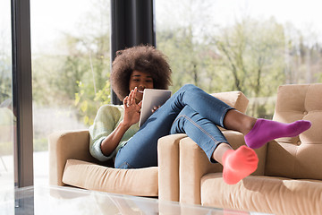 Image showing young african american woman at home using digital tablet