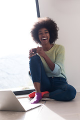 Image showing black woman in the living room on the floor