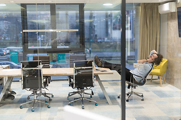 Image showing young businessman relaxing at the desk
