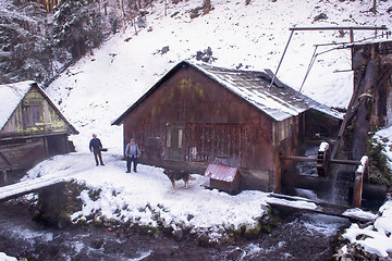 Image showing two confident blacksmith in front of watermill