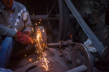 Image showing the blacksmith polishing metal products