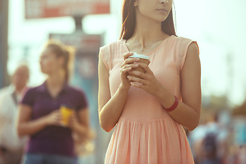 Image showing Beautiful girls holding paper coffee cup and enjoying the walk in the city