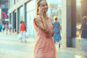 Image showing Young Beautiful Woman Talking On Mobile Phone Outdoor.