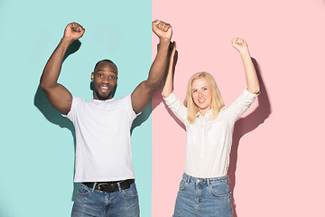 Image showing We won. Winning success happy afro man and woman celebrating being a winner. Dynamic image of caucasian female and male model on pink studio.
