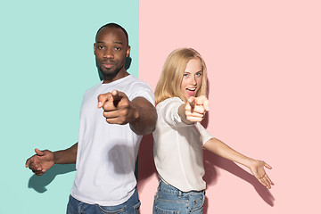 Image showing The happy couple point you and want you, half length closeup portrait on studio background.