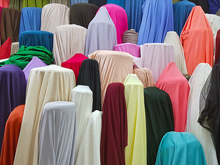 Image showing Colorful rolls of satin fabrics for sale in the market