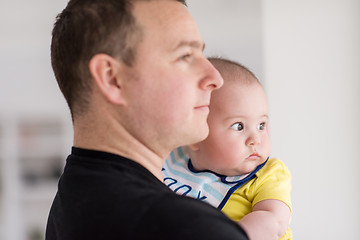 Image showing young father holding baby near the window at home