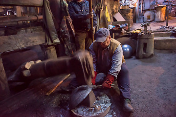 Image showing blacksmith workers using mechanical hammer at workshop