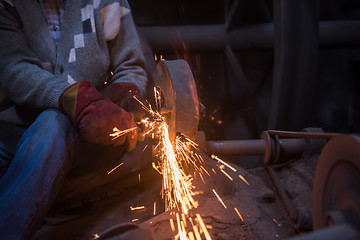 Image showing the blacksmith polishing metal products