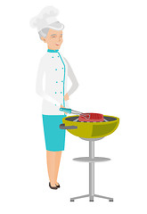 Image showing Caucasian chef cooking meat on barbecue grill.