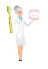 Image showing Dentist with dental jaw model and toothbrush.