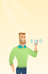 Image showing Young caucasian man holding ringing mobile phone.