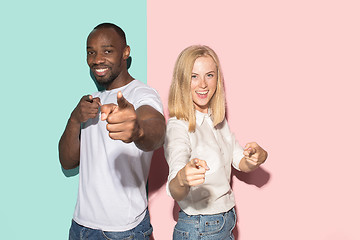 Image showing The happy couple point you and want you, half length closeup portrait on studio background.