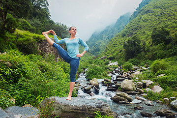 Image showing Woman doing Ashtanga Vinyasa Yoga asana outdoors at waterfall