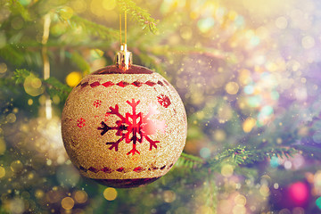 Image showing Christmas-tree decoration bauble on decorated Christmas tree bac