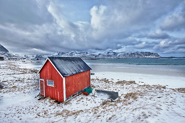 Image showing Red rorbu house shed on beach of fjord, Norway