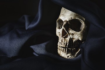 Image showing Closeup photo an old skull covered in black robe