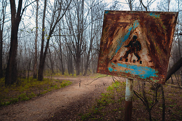 Image showing Damaged pedestrian sign at forestal road