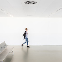 Image showing Motion blur of woman walking at contemporary white empty hallway