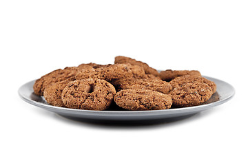 Image showing Fresh baked chocolate chip cookies heap on grey plate isolated o