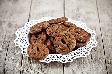 Image showing Fresh baked chocolate chip cookies heap on white plateon rustic 