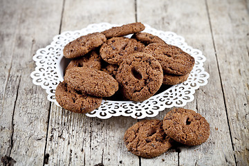 Image showing Fresh baked chocolate chip cookies heap on white plateon rustic 