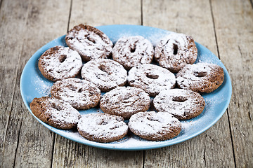 Image showing Fresh baked chocolate chip cookies with sugar powder on blue pla
