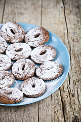 Image showing Fresh baked chocolate chip cookies with sugar powder on blue pla