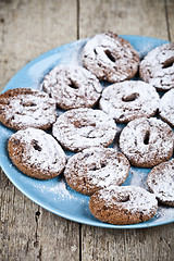 Image showing Fresh baked chocolate chip cookies with sugar powder on blue pla