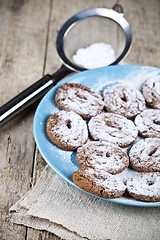 Image showing Fresh baked chocolate chip cookies with sugar powder on blue pla