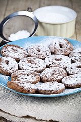 Image showing Fresh baked chocolate chip cookies with sugar powder on blue pla