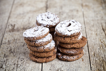 Image showing Fresh baked chocolate chip cookies with sugar powder stacks on w