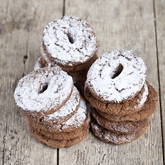 Image showing Fresh baked chocolate chip cookies with sugar powder stacks on w