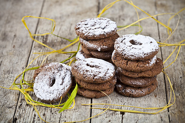 Image showing Fresh baked chocolate chip cookies with sugar powder stacks on w